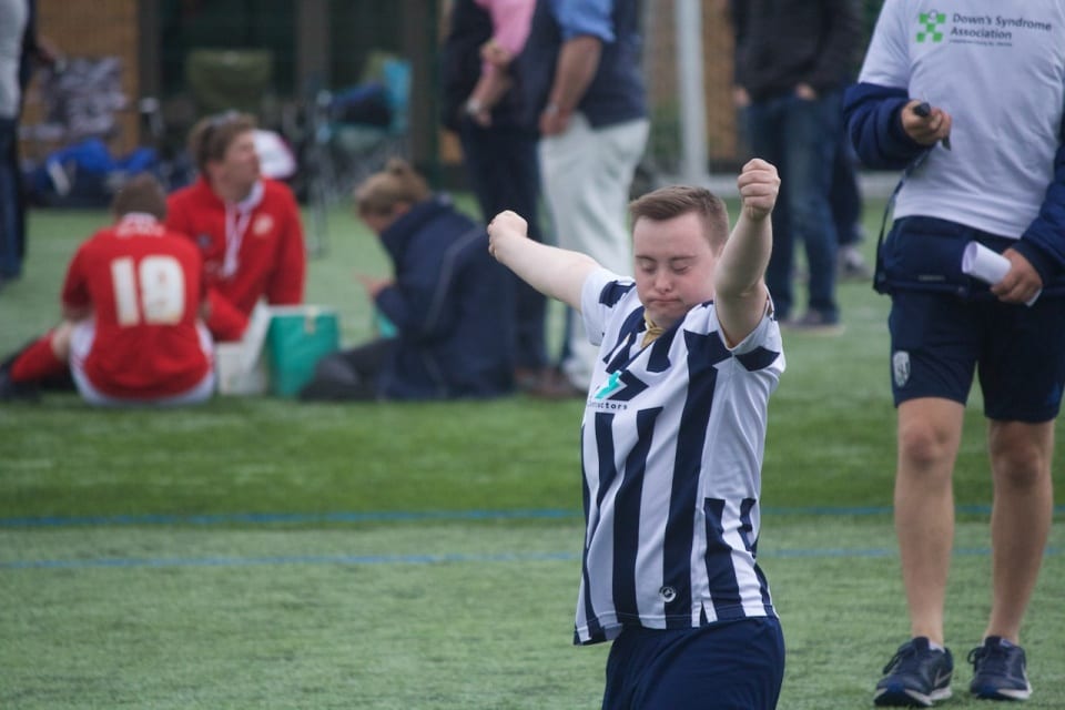A football player, who has Down's syndrome, celebrates on the pitch