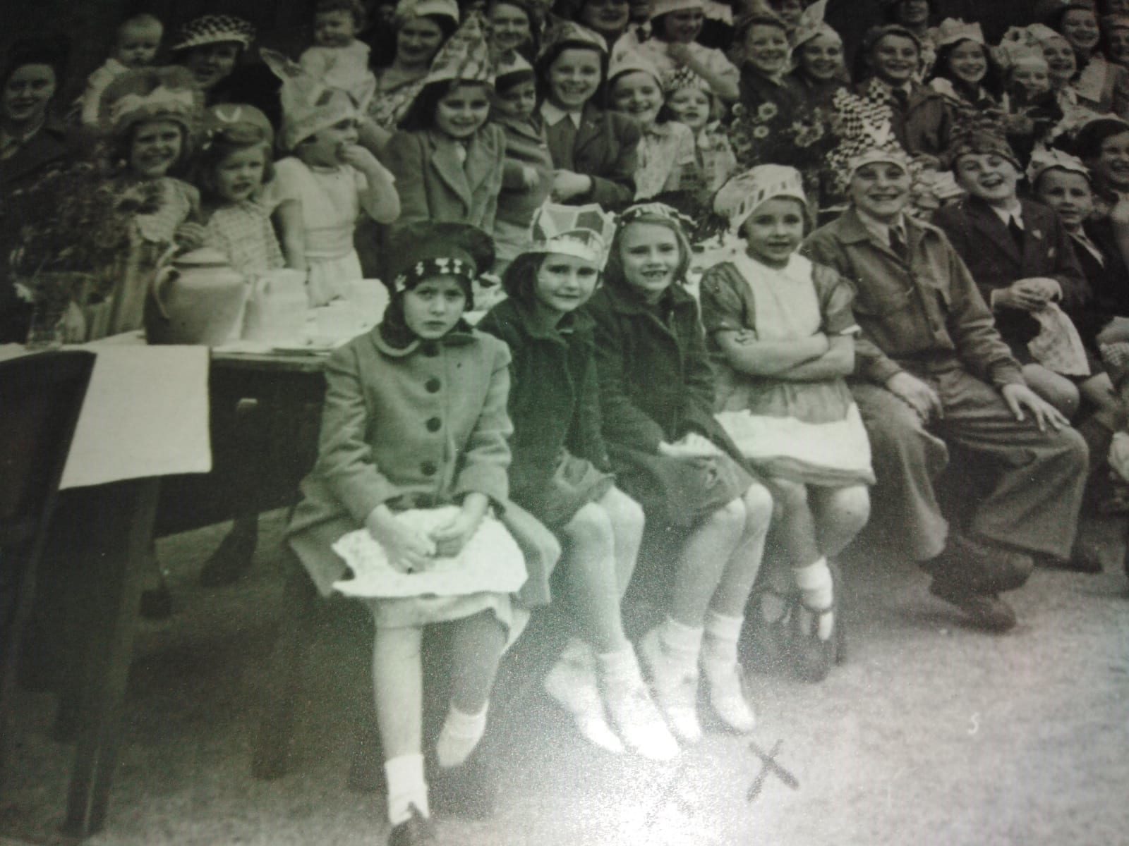 An old black and white picture of a crowd of children celebrating VE day in 1945