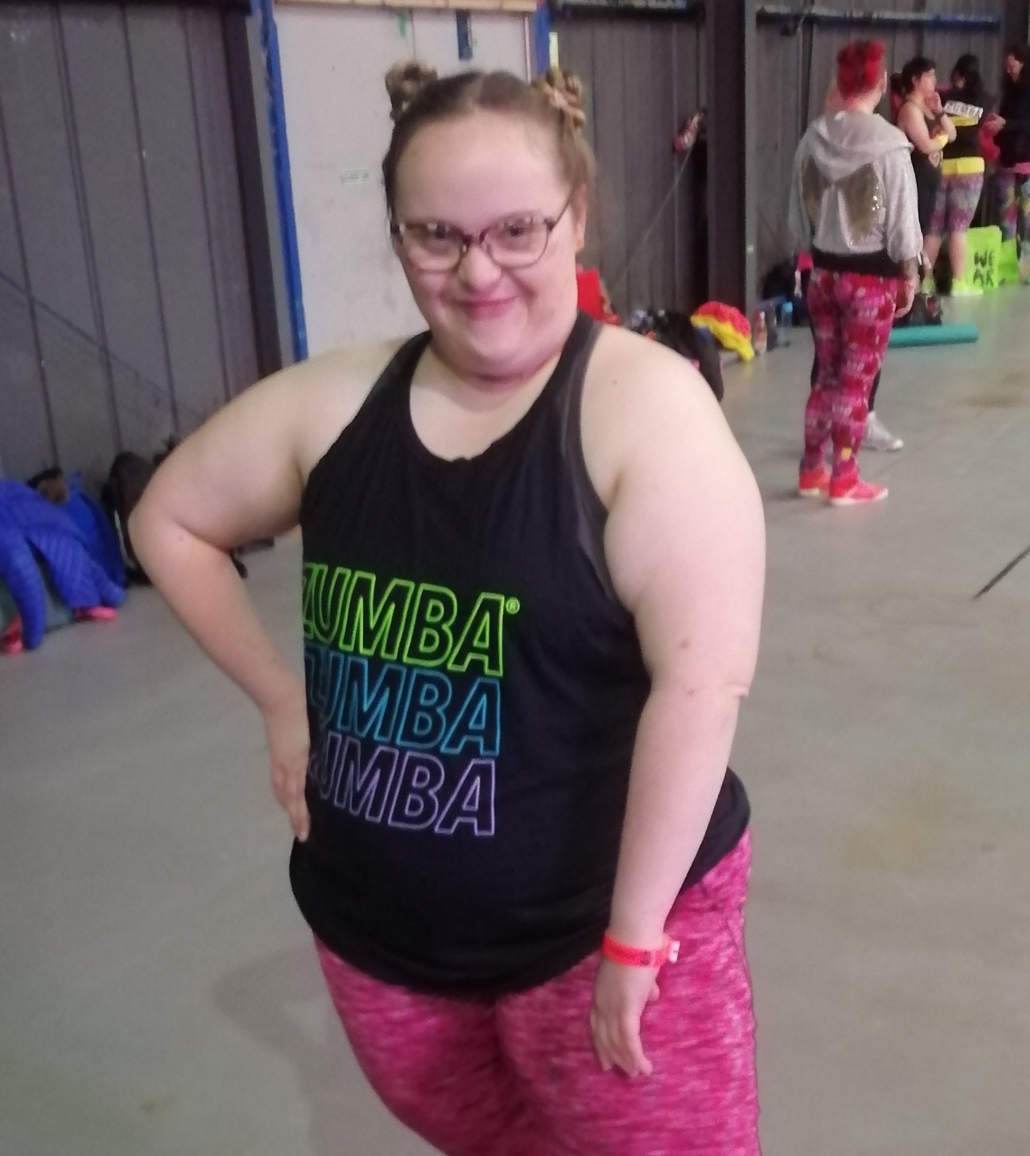 A young woman who has Down's syndrome in exercise gear poses for a photo