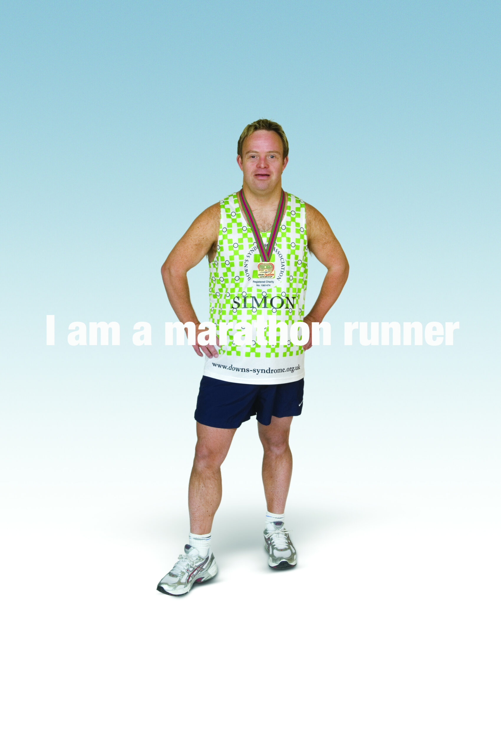 A posed photograph of Simon in his running gear with his London Marathon medal around his neck. Text across the image says 'I am a marathon runner'