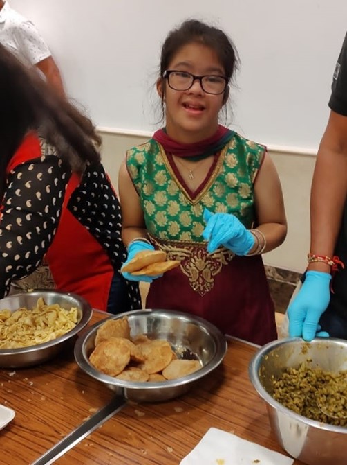 Harshi serves food alongside other volunteers.