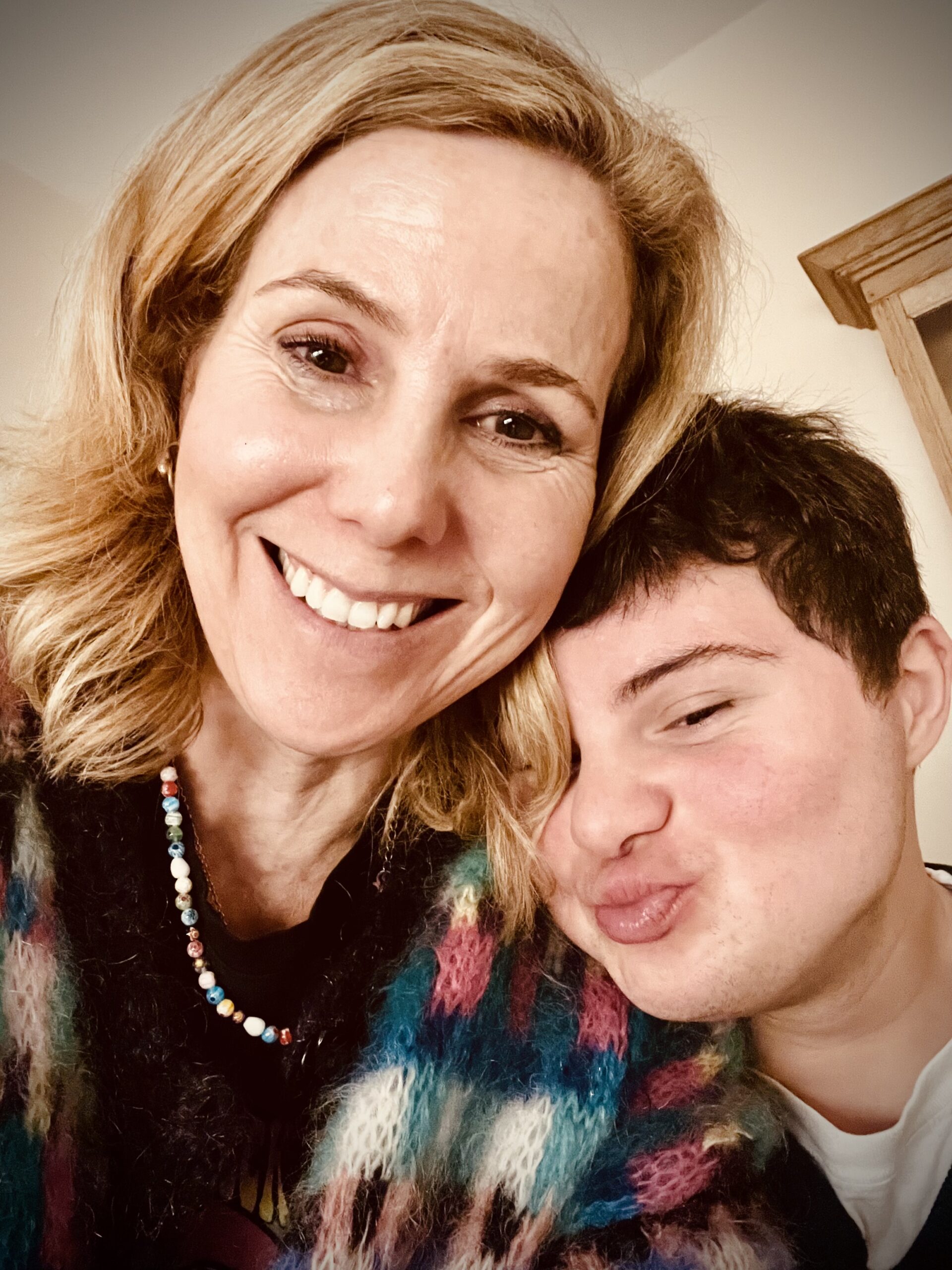 Actor Sally Phillips and son Olly smile to camera