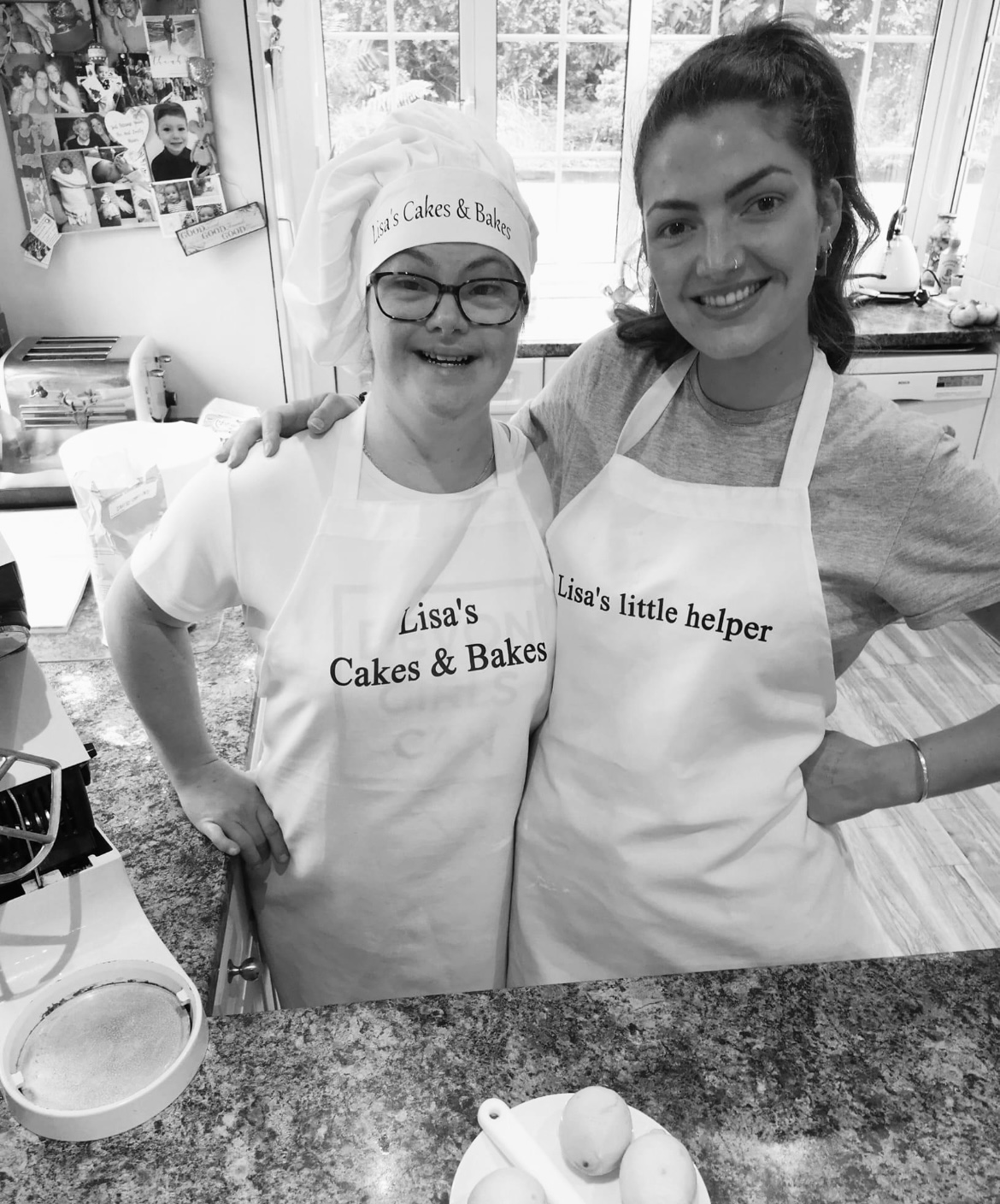 Two women wearing cooking aprons