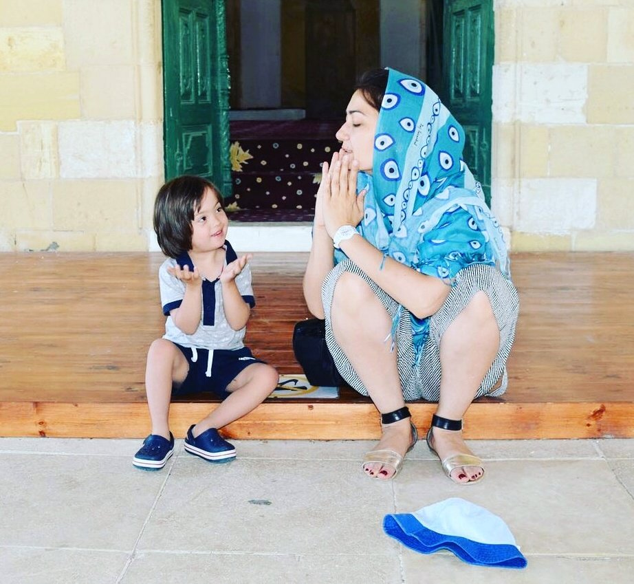 A mum and a small boy who has Down's syndrome pray together in a mosque.