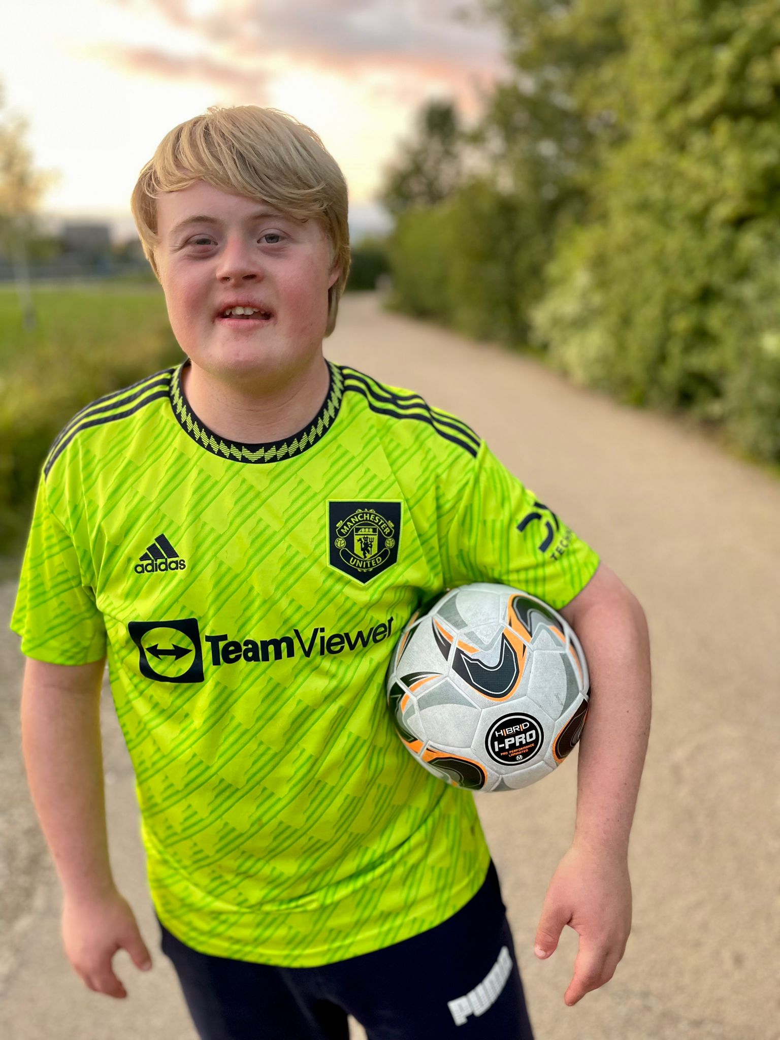 Boy wearing football strip and holding a football