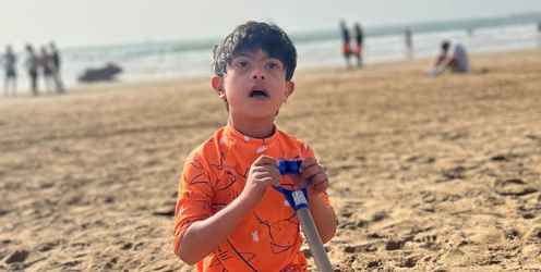 Boy on a beach with a spade